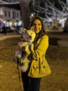 A person named Rianna holding her pomsky dog in winter