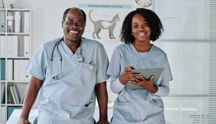 male and female veterinary professionals wearing light blue scrubs
