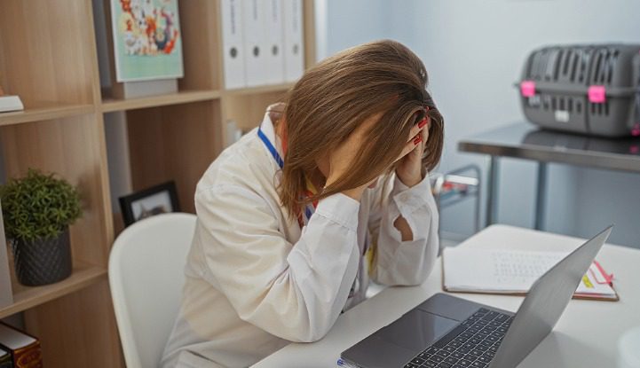 Tired female Veterinarian resting her head on her hands