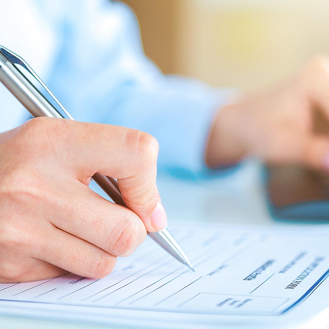 man using pen to fill out application