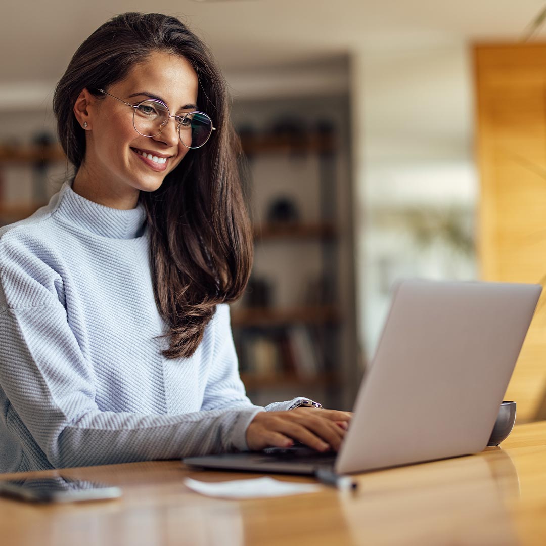 woman smiling while using laptop