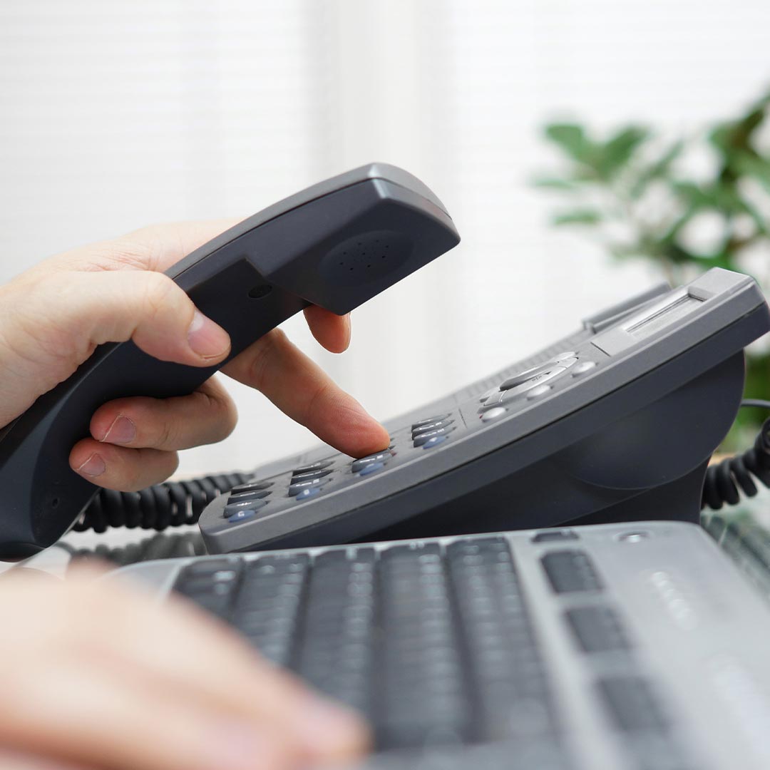 businessman dialing phone number in office